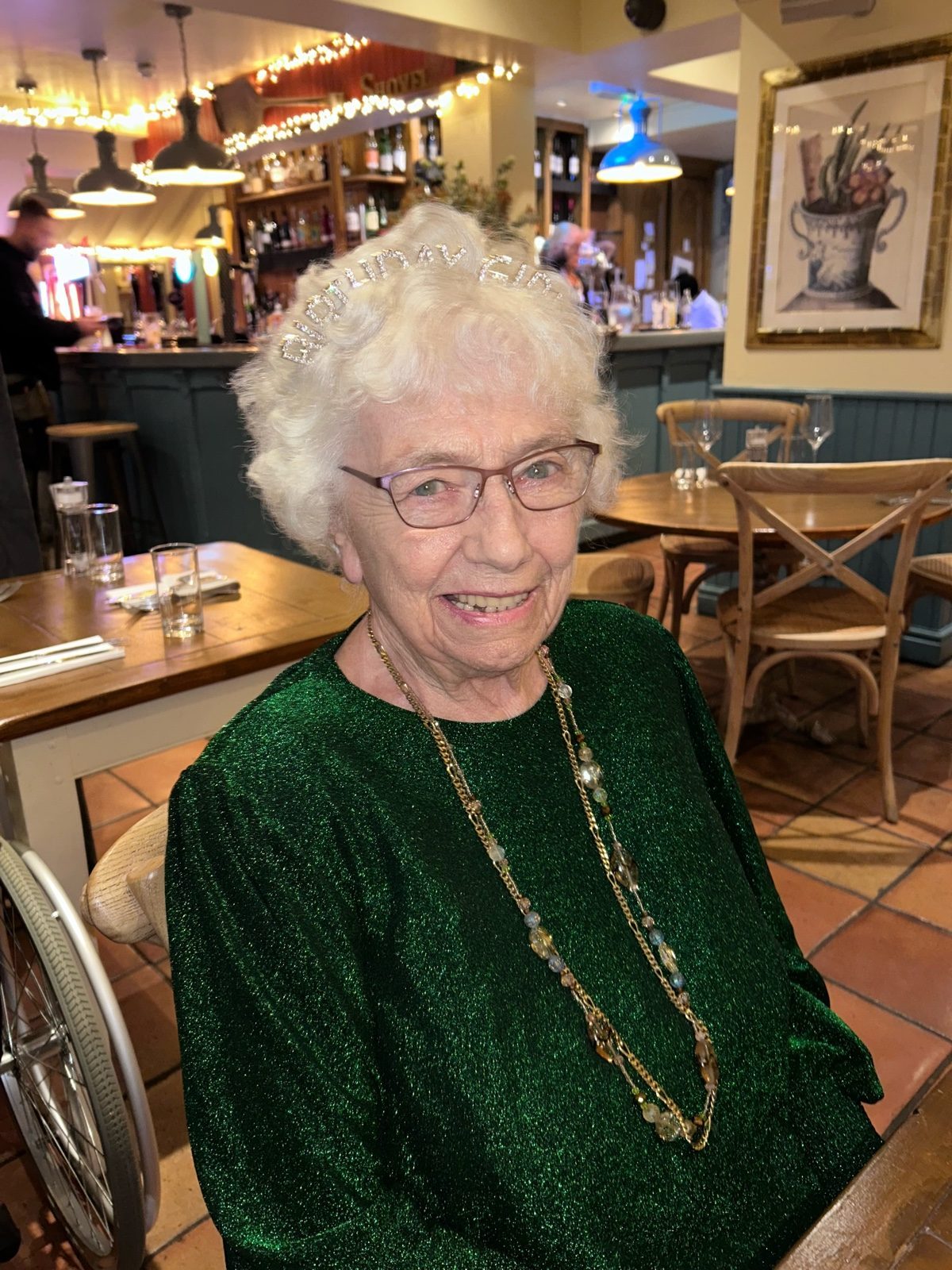 Beth, smiling, in her sparkly top and a birthday tiara